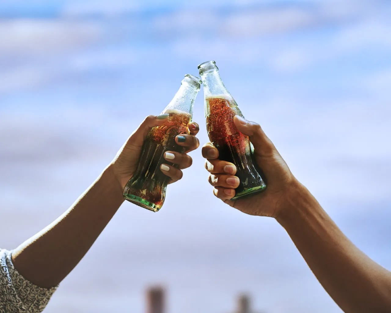 Two Coca-Cola Bottles in hands