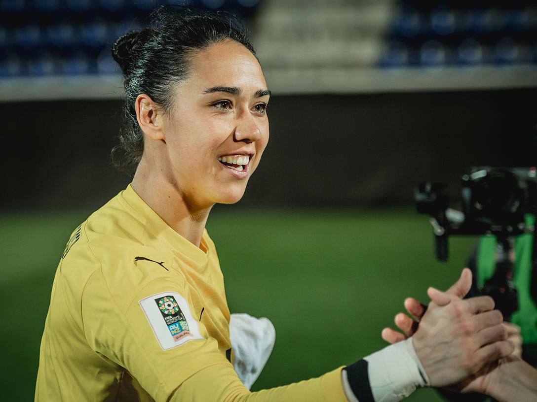 ÖFB-Torfrau Manuela Zinsberger lächelnd im gelben Nationalteam-Trikot.