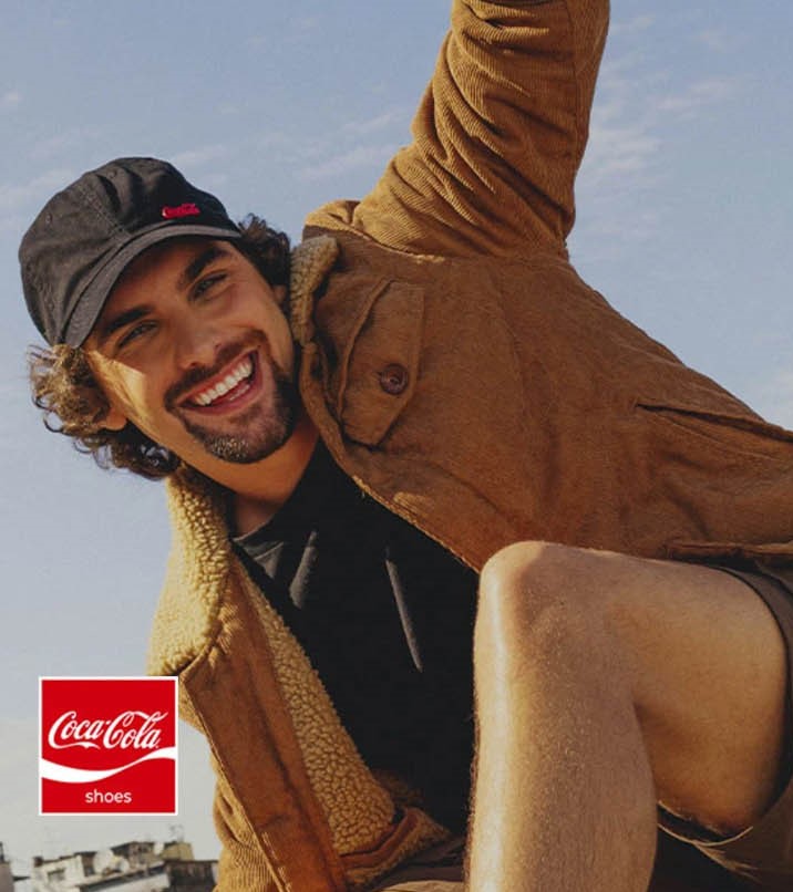 Um jovem vestido com produtos oficiales da Coca Cola