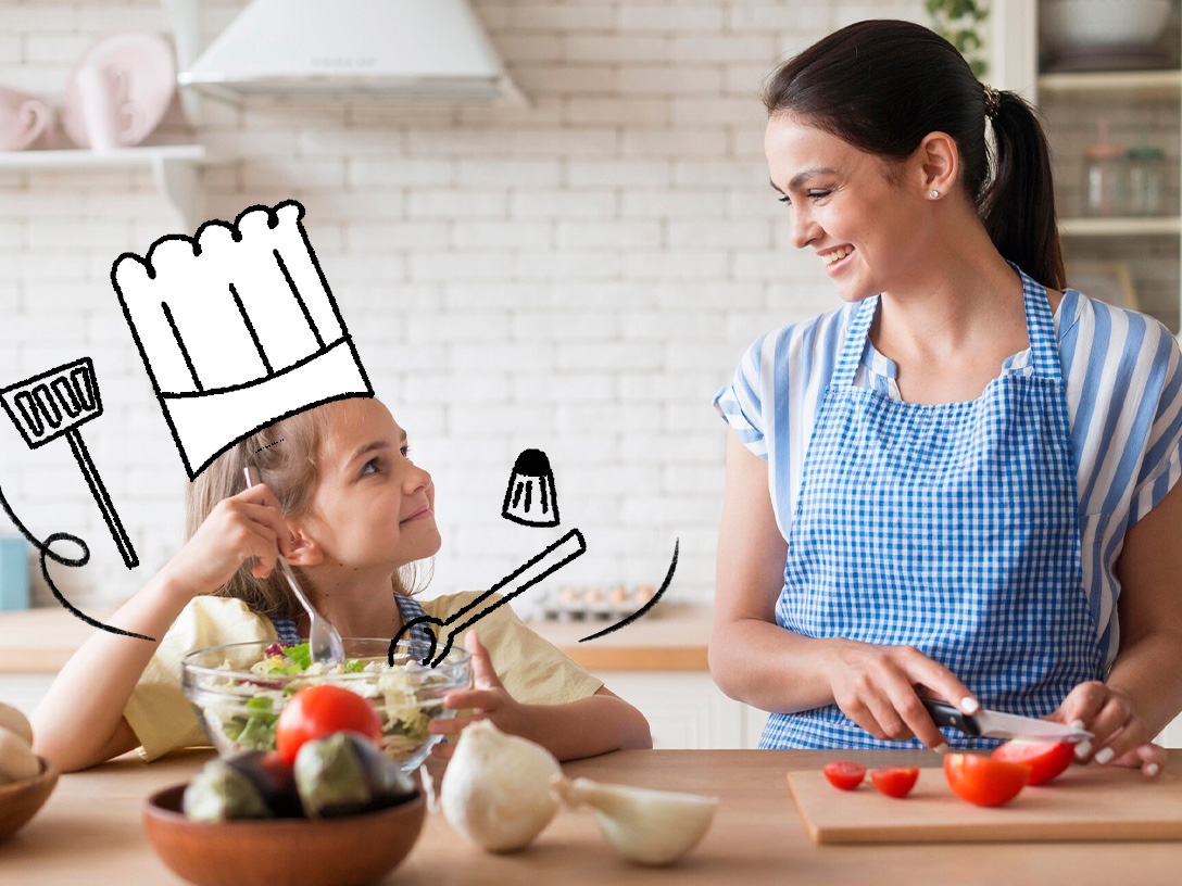 Uma mãe e sua filha sorriem enquanto preparam uma salada juntas na cozinha. A menina segura um garfo e observa atentamente os ingredientes, enquanto a mãe corta tomates em uma tábua. Um desenho de chapéu de chef flutua sobre a cabeça da menina, acompanhado de desenhos de utensílios de cozinha.