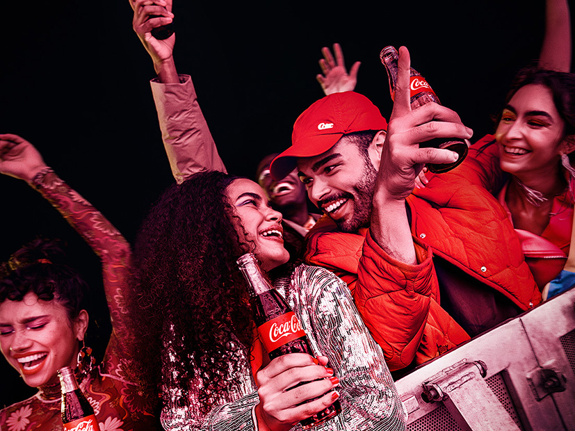 Grupo de pessoas curtindo Coca-Cola em um evento.