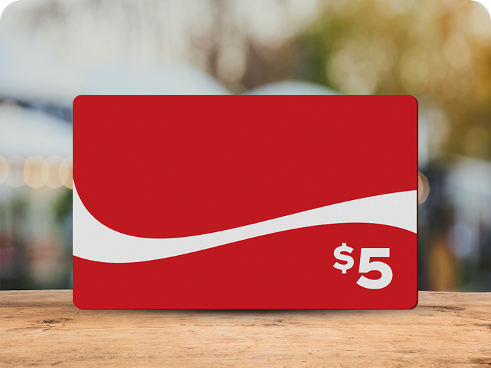 A red Coca-Cola branded $5 prepaid gift card with the dynamic ribbon, a prize available in the Summer Scratch-Off contest.