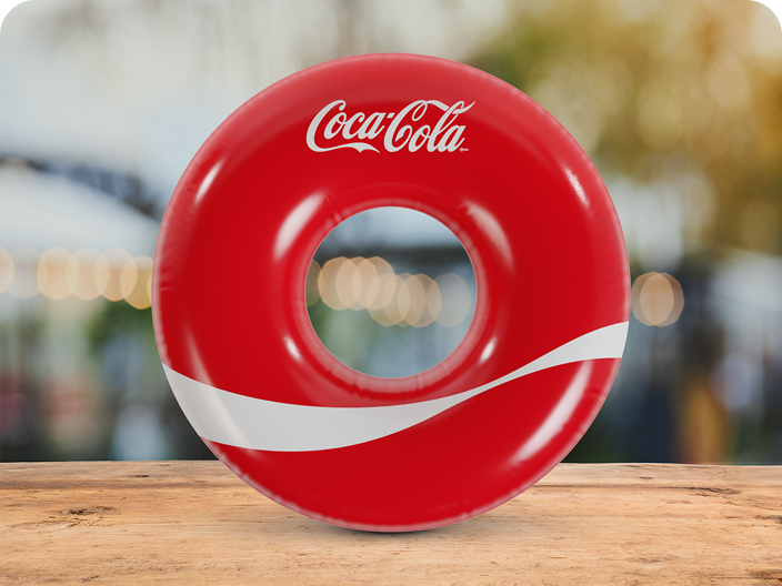 A red inflatable Coca-Cola pool float with the classic white ribbon, a fun prize from the Summer Scratch-Off promotion.