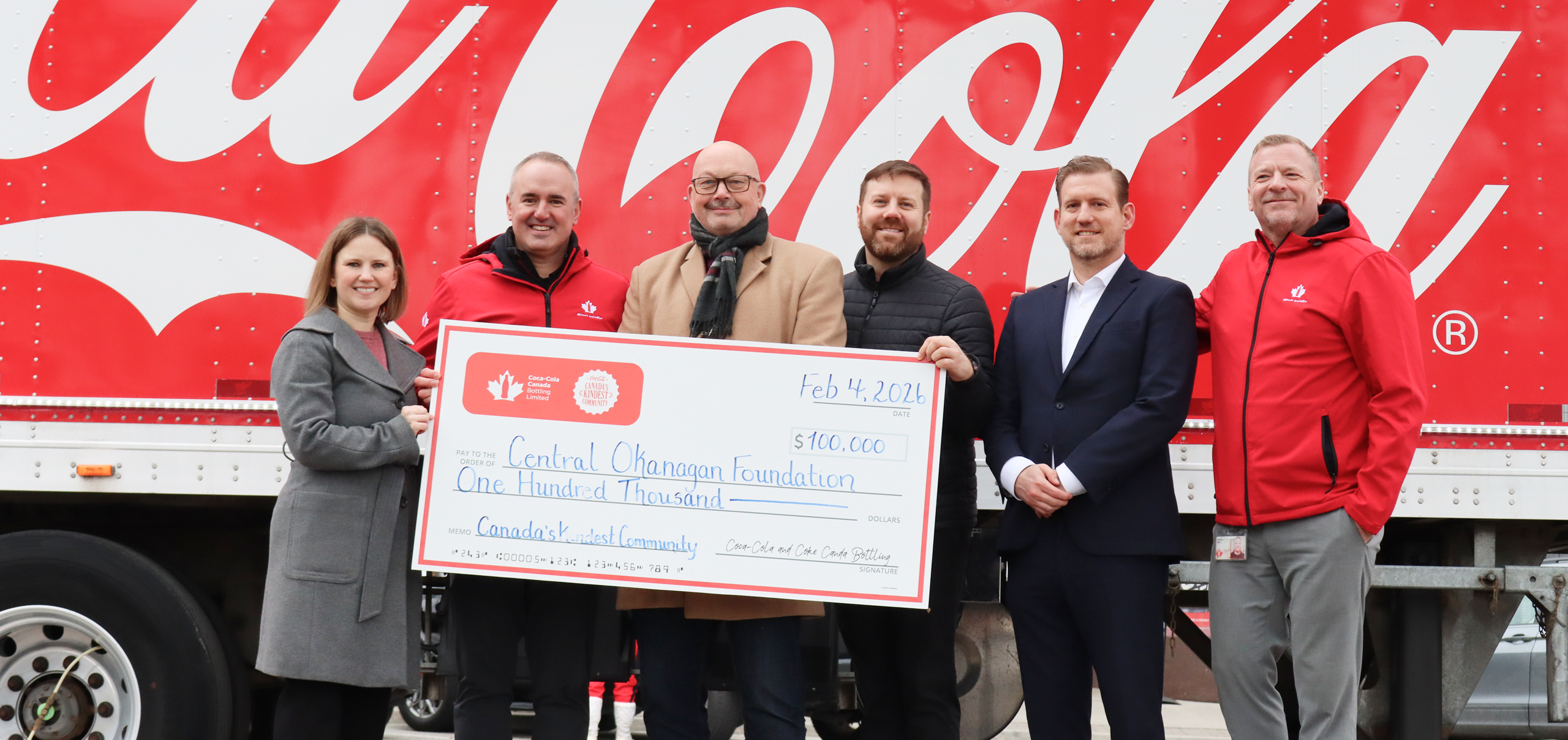 A group of people holding a check for winning Canada's Kindest community 