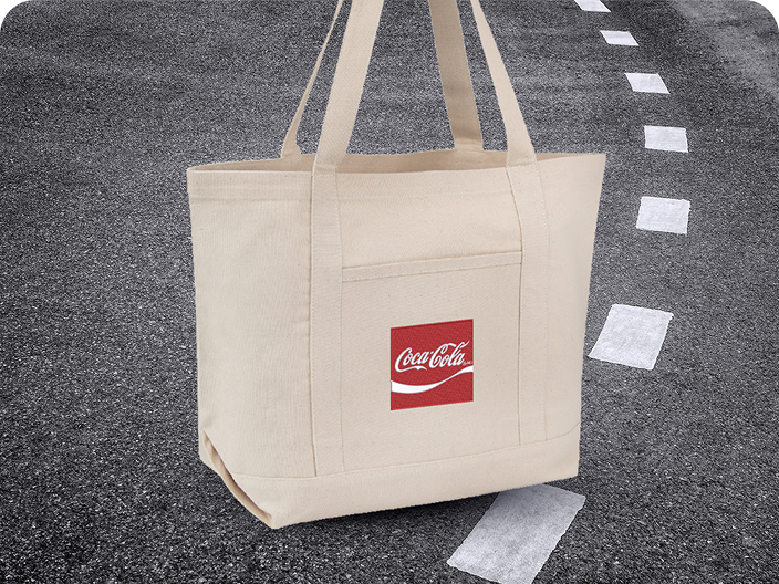 Un sac fourre-tout en toile beige avec un écusson rouge Coca-Cola, un prix pratique du lot du concours Voyage en voiture.