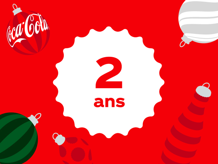 A red festive graphic featuring a white bottle-cap-shaped badge with "2 ans" (French for "2 years") in red text, surrounded by Christmas ornaments including a Coca-Cola-branded bauble, a striped white ornament, a dark green ornament, and a red-and-white striped ornament resembling a stocking or party hat.