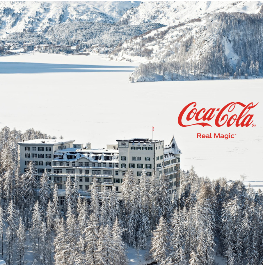 Roter Glacier Express-Zug auf Steinviadukt in verschneiter Alpenlandschaft mit Coca-Cola Logo