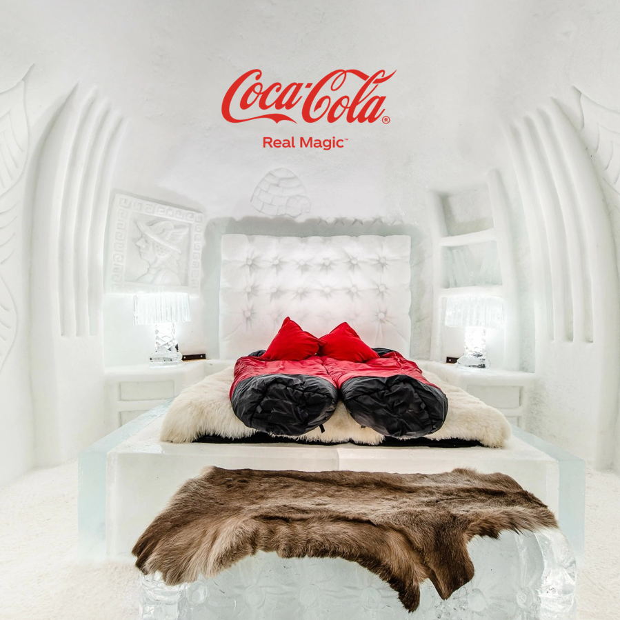 Roter Glacier Express-Zug auf Steinviadukt in verschneiter Alpenlandschaft mit Coca-Cola Logo