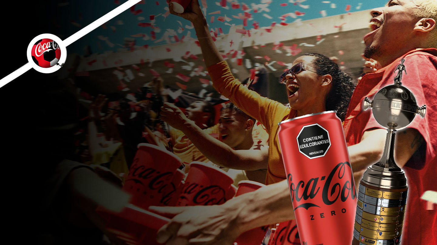 Fotografía de una multitud en un estadio. A la derecha, una lata de "Coca-Cola Zero" y una Copa Conmebol Libertadores™