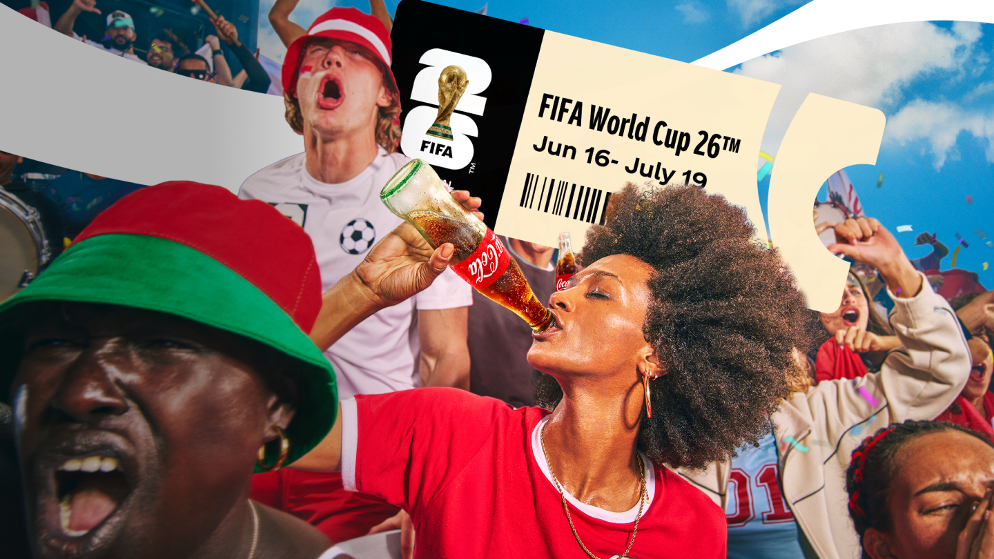 Juichende voetbalfans in rode en groene kleding vieren feest in een stadionachtige setting; iemand drinkt uit een Coca‑Cola‑fles terwijl op de achtergrond confetti, vlaggen en een groot FIFA World Cup 26‑ticket met datum zichtbaar zijn tegen een blauwe lucht.