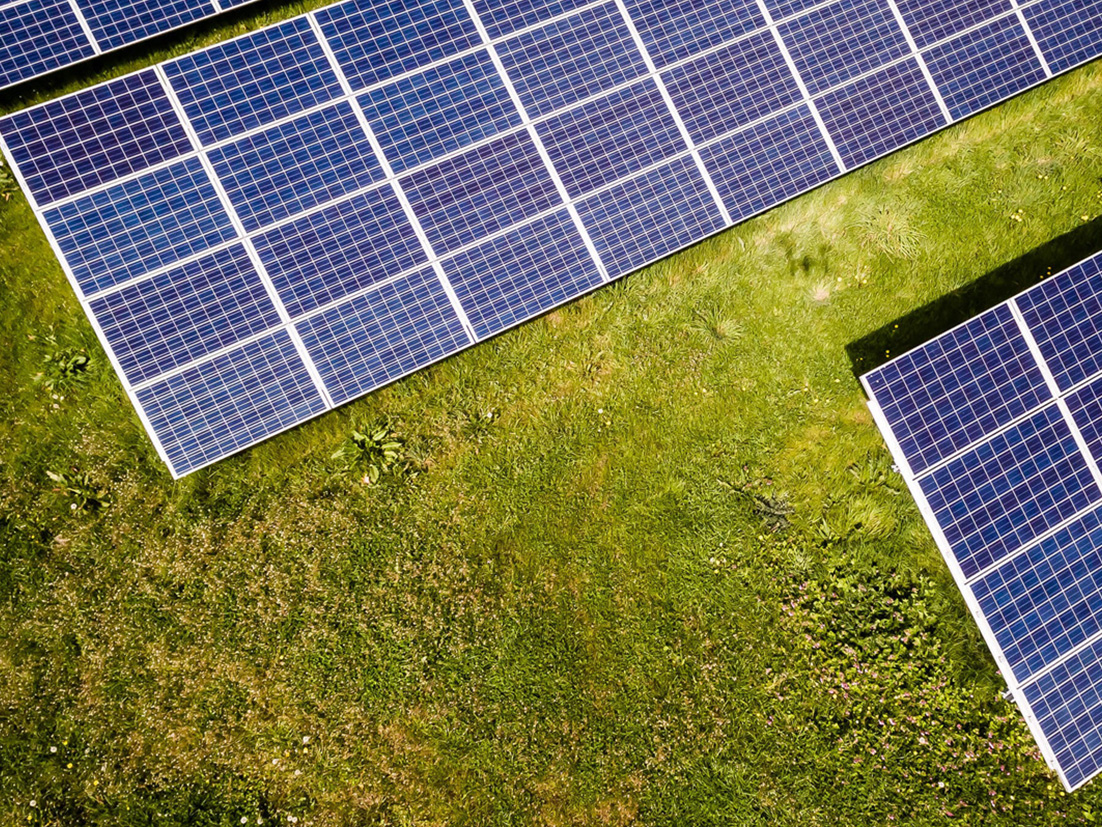 Top view of solar cell panels on a green field