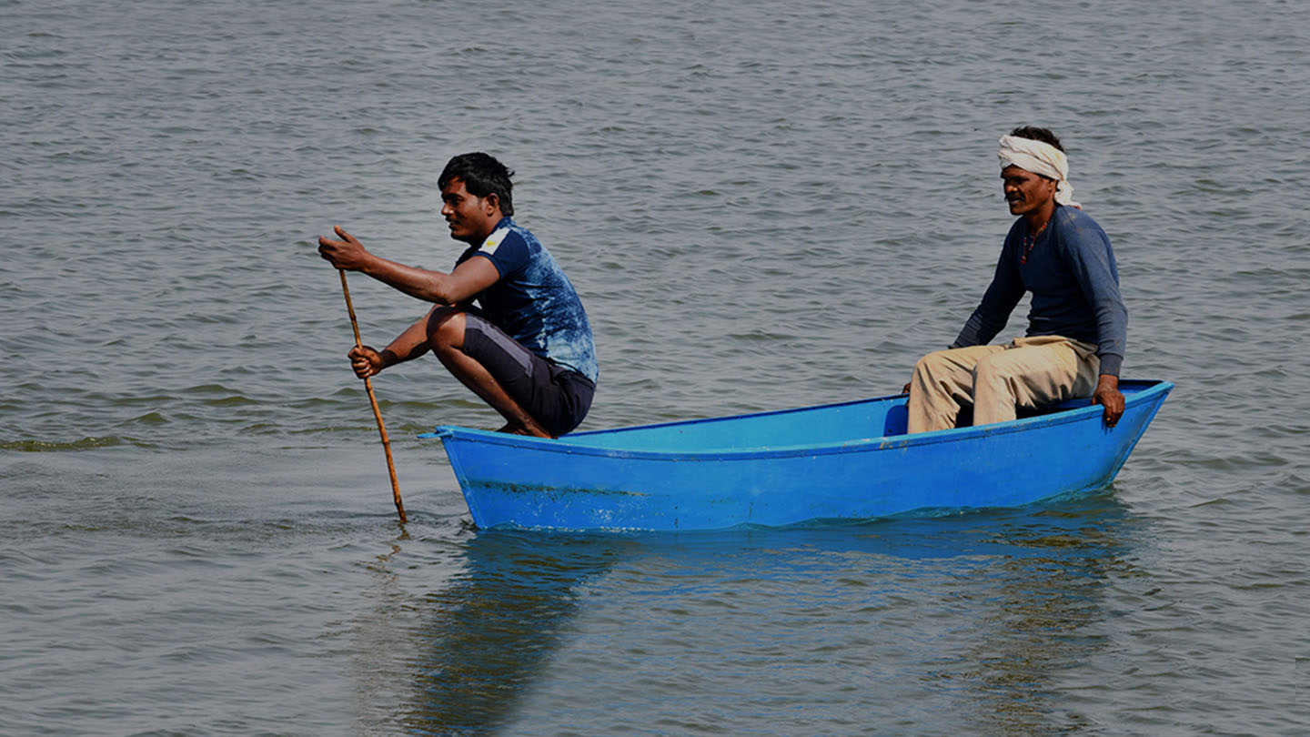 नीले रंग की नाव में बैठे दो आदमी