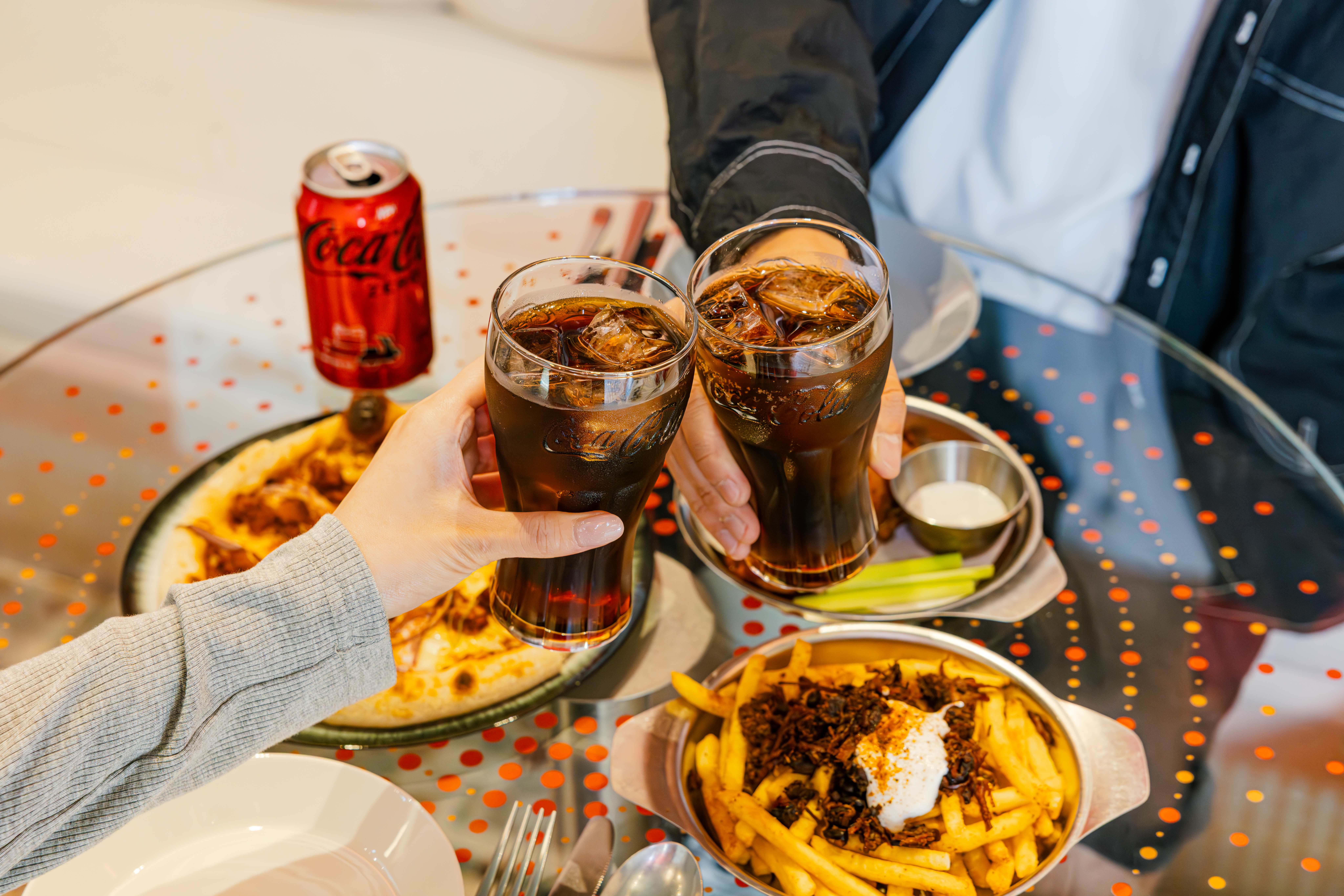 코카-콜라 콤보 메뉴인 치폴레 치킨 피자와 비프 베이컨 감자튀김, 그리고 버팔로윙과 함께 코카-콜라 제로를 즐기는 사진.