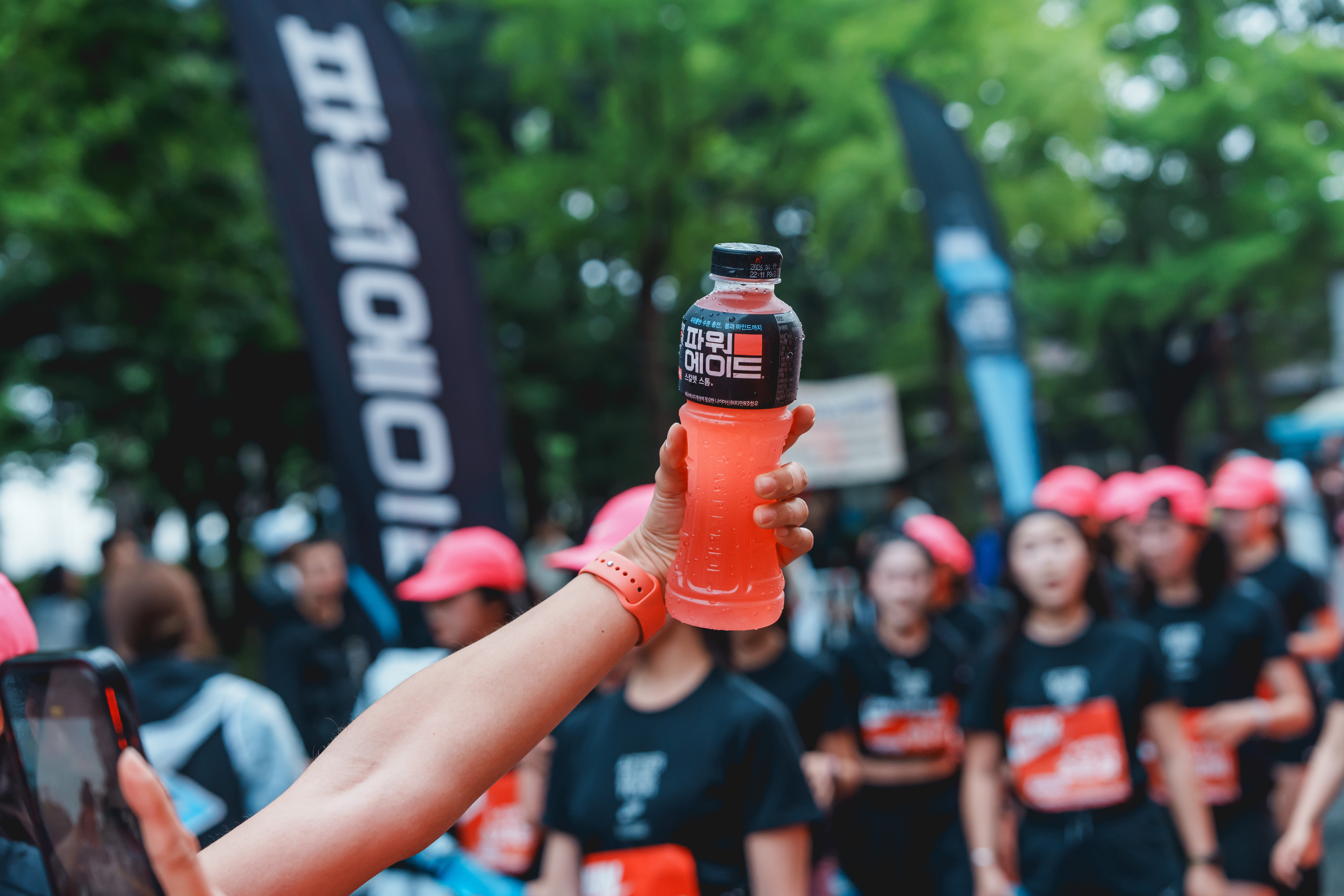 마라톤 대회에 참가한 러너들이 자신이 좋아하는 파워에이드와 함께 러닝 인증샷을 남기고 있는 모습
