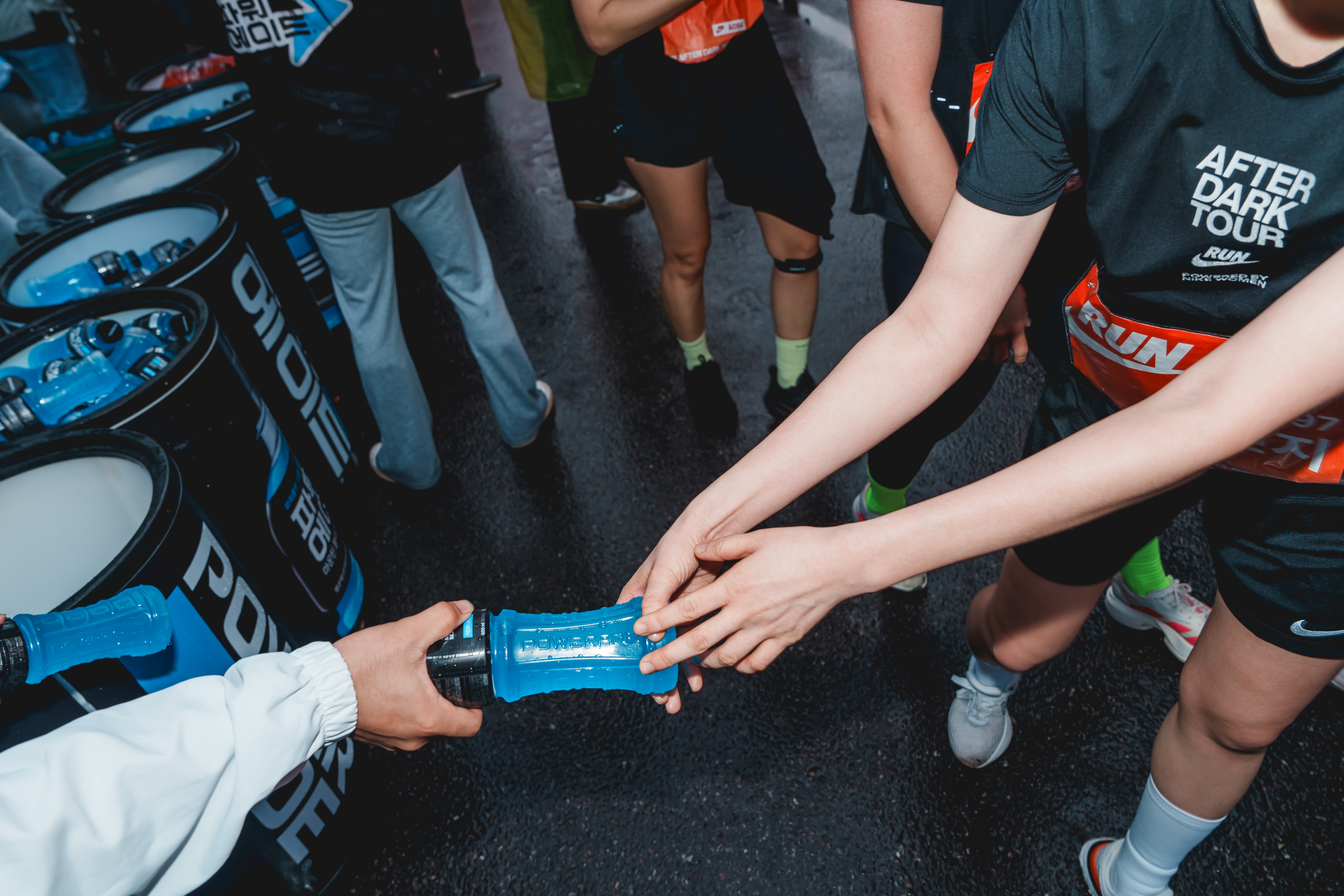 마라톤 대회에서 진행된 파워에이드 샘플링 현장에서 러너들이 시원하게 칠링된 파워에이드를 받아가고 있는 모습