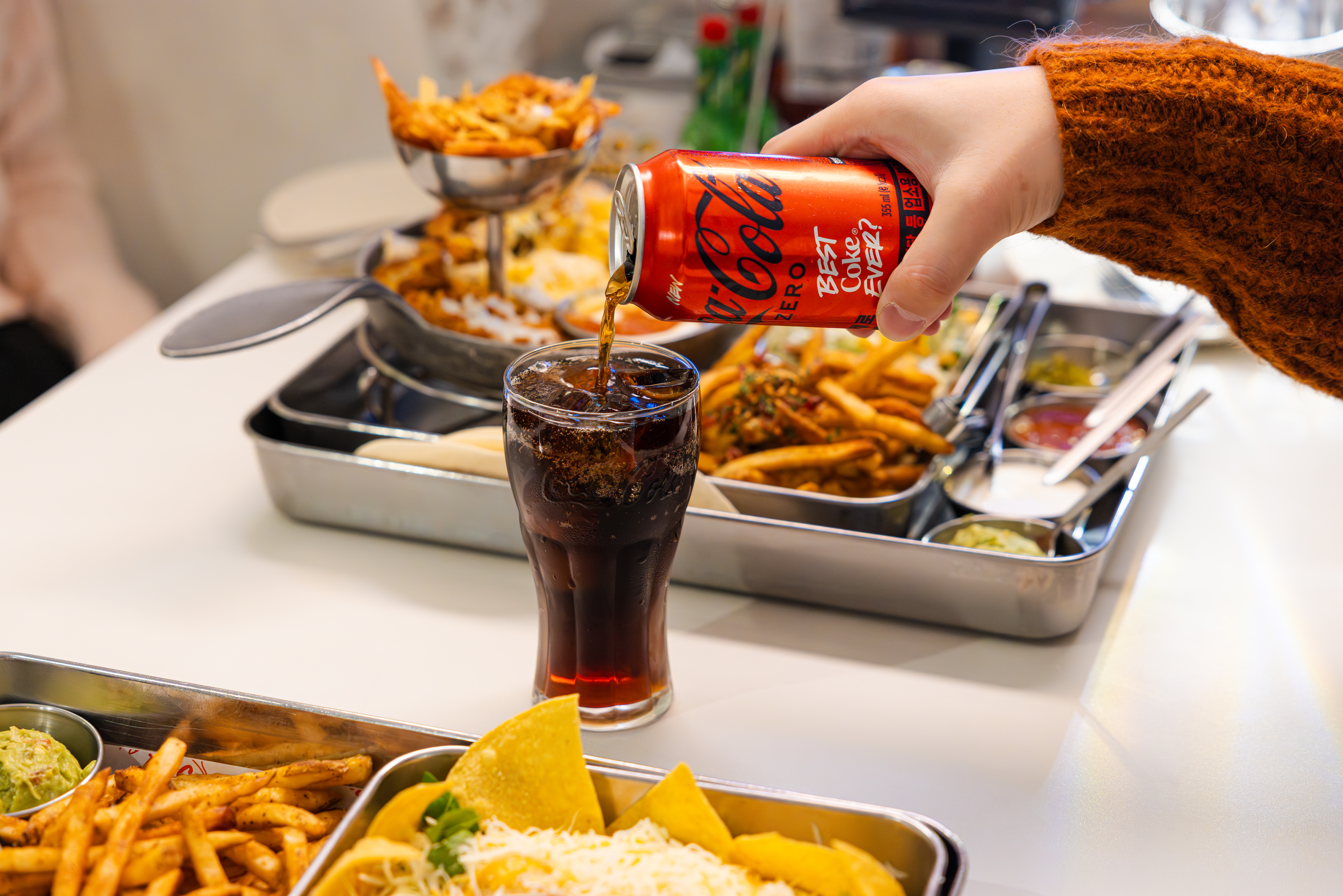 '타코튜즈데이'의 대표메뉴, 서울숲 갈릭 플래터와 갈릭 소울 3단 파히타와 코카-콜라 제로를 함께 즐기고 있다.