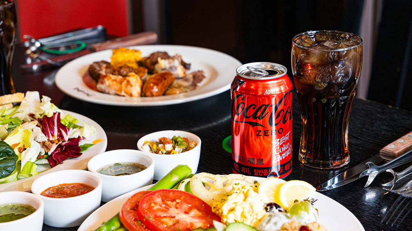 레드리본 인증을 받은 레스토랑의 대표 메뉴들과 코카-콜라 제로가 테이블 위에 맛있게 차려져있는 모습