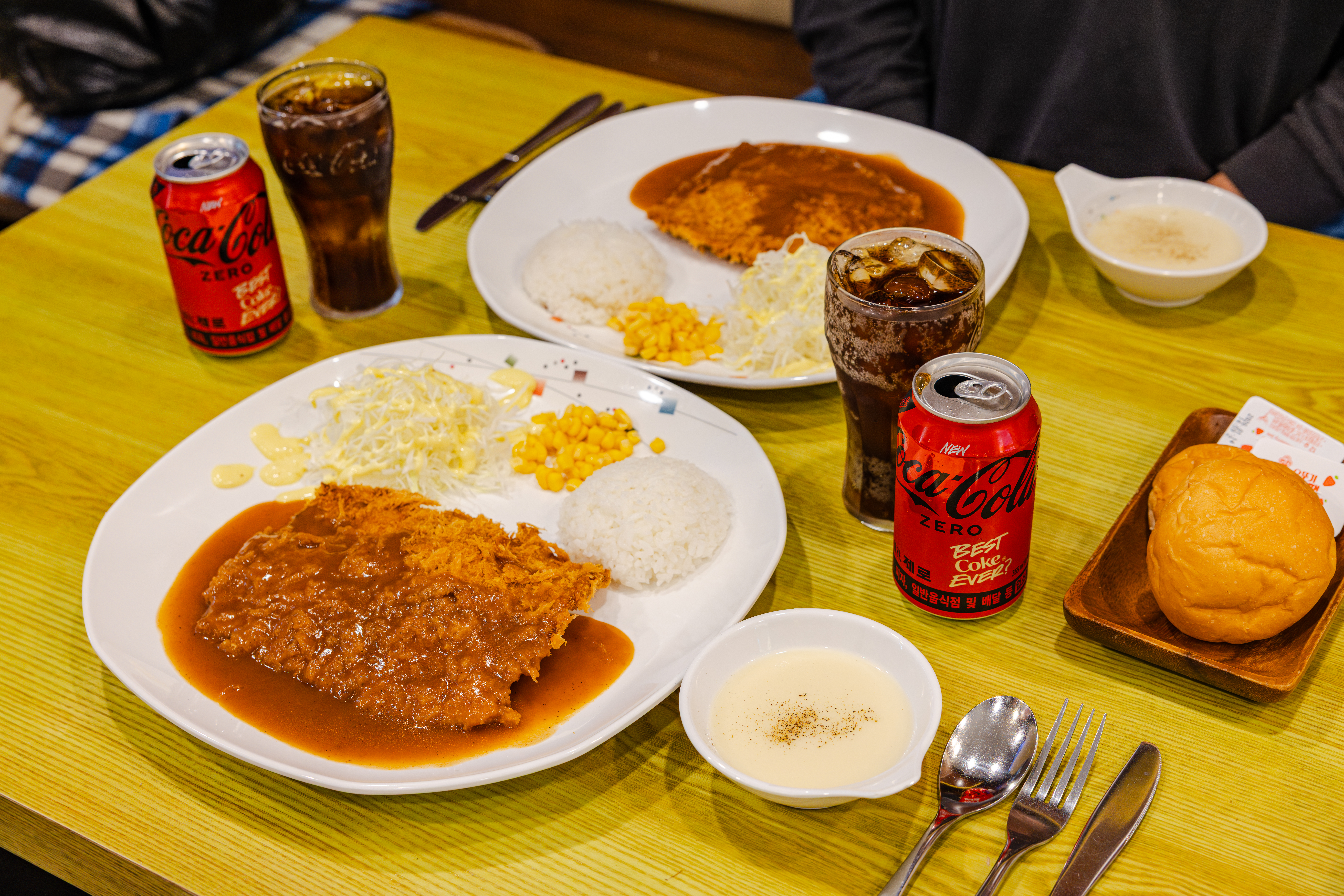 해방촌 수제돈가스의 대표메뉴, 등심돈가스와 치즈 돈가스를 코카-콜라 제로와 함께 즐기고 있다.