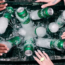Latas de Sprite dentro de un contenedor con hielo y agua.