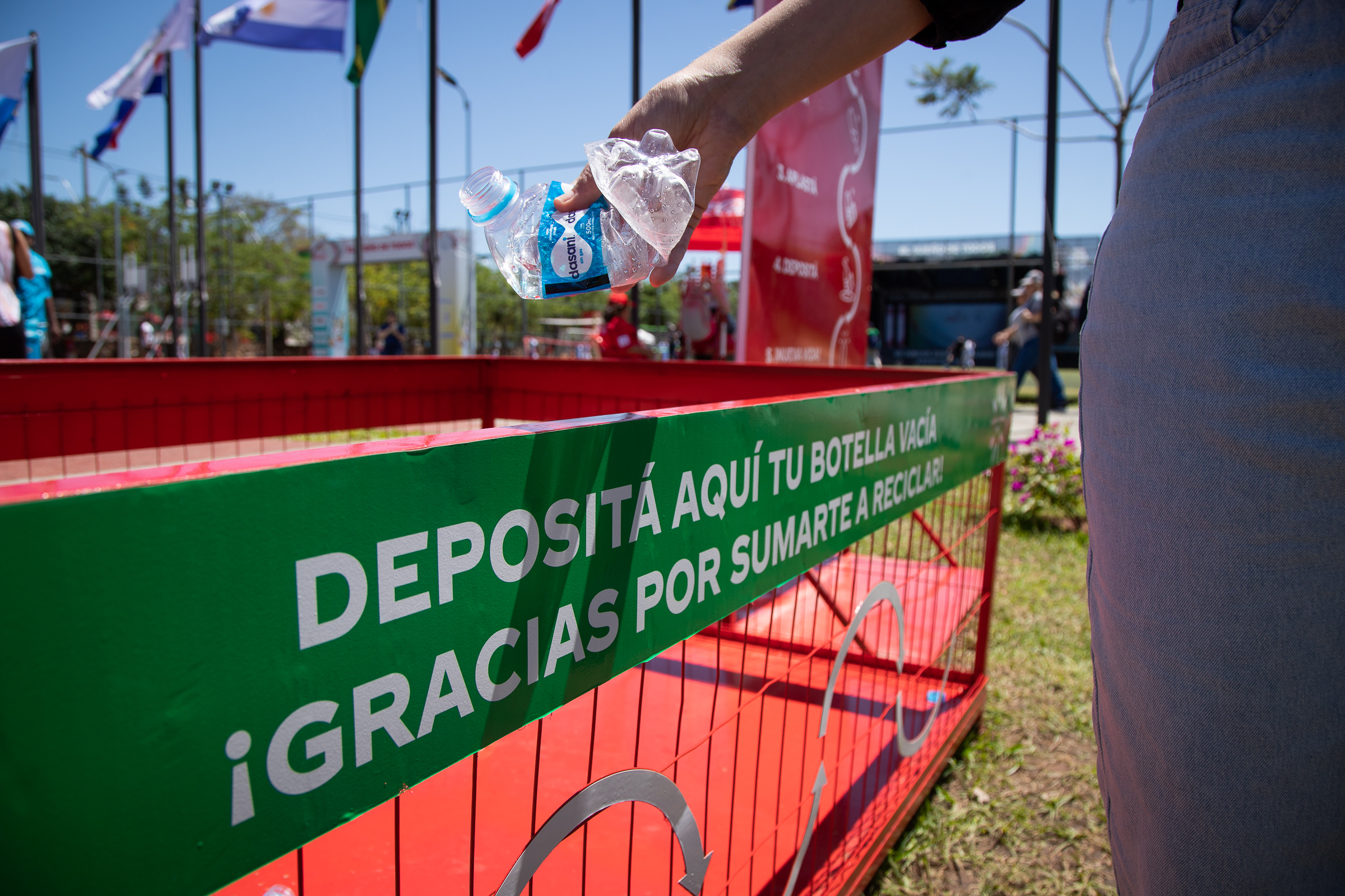 Persona depositando botella en punto de reciclaje