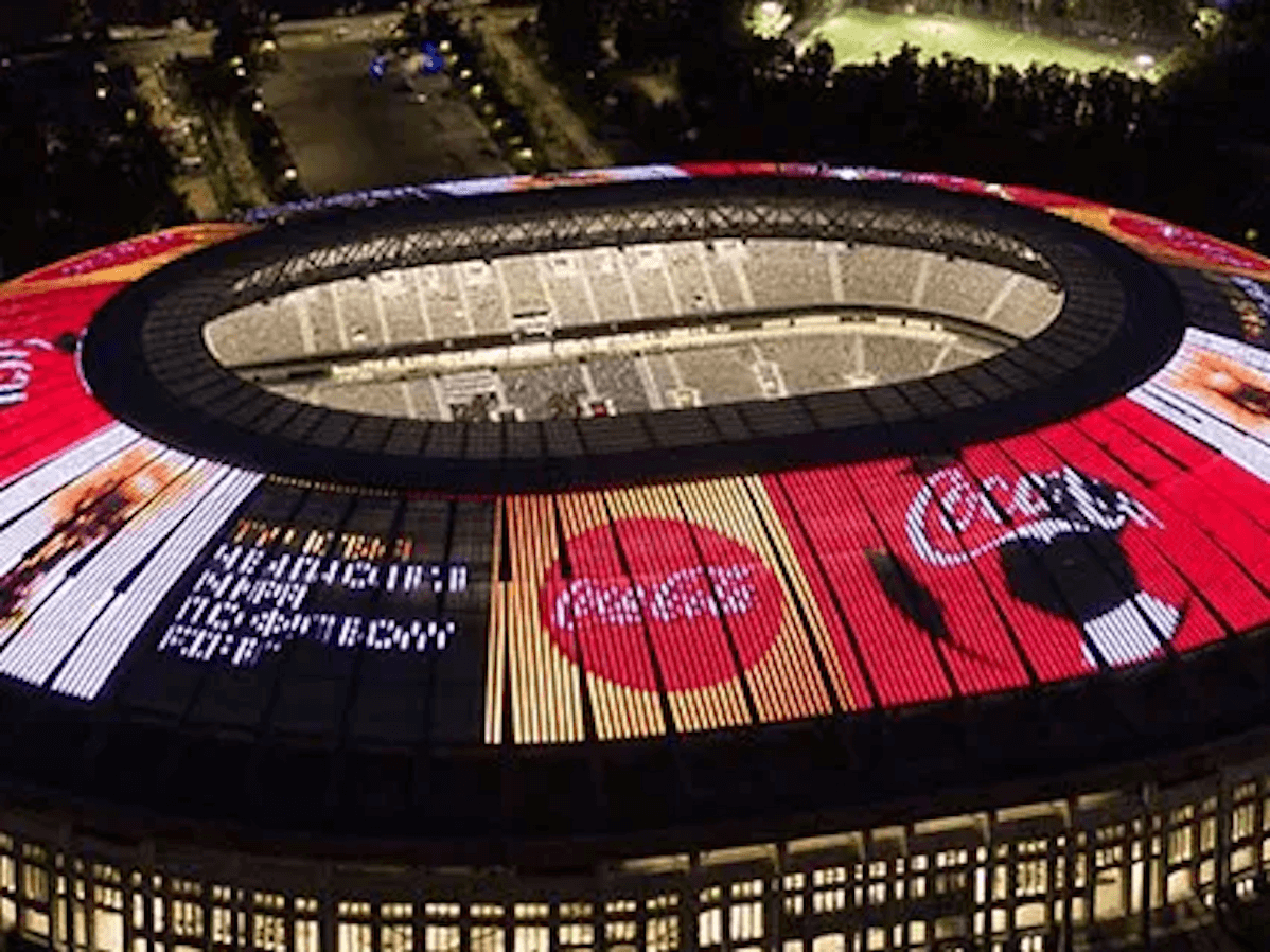 Top view of a football stadium at night with Coca-Cola advertising on top of it