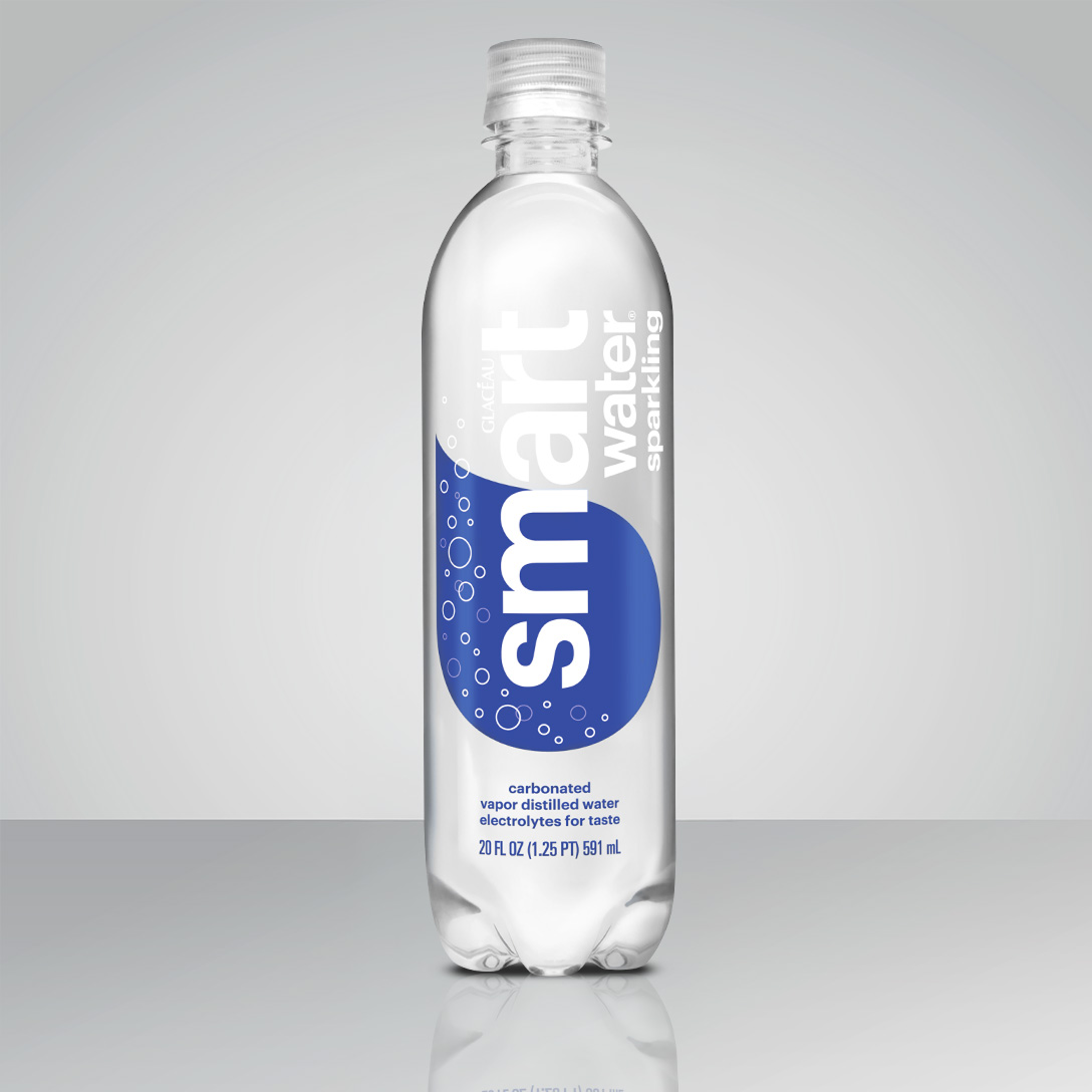 A clear plastic Glacéau Smartwater Sparkling bottle with a blue label reading "carbonated vapor distilled water, electrolytes for taste, 20 FL OZ (1.25 PT) 591 mL," standing on a reflective surface against a gray background.