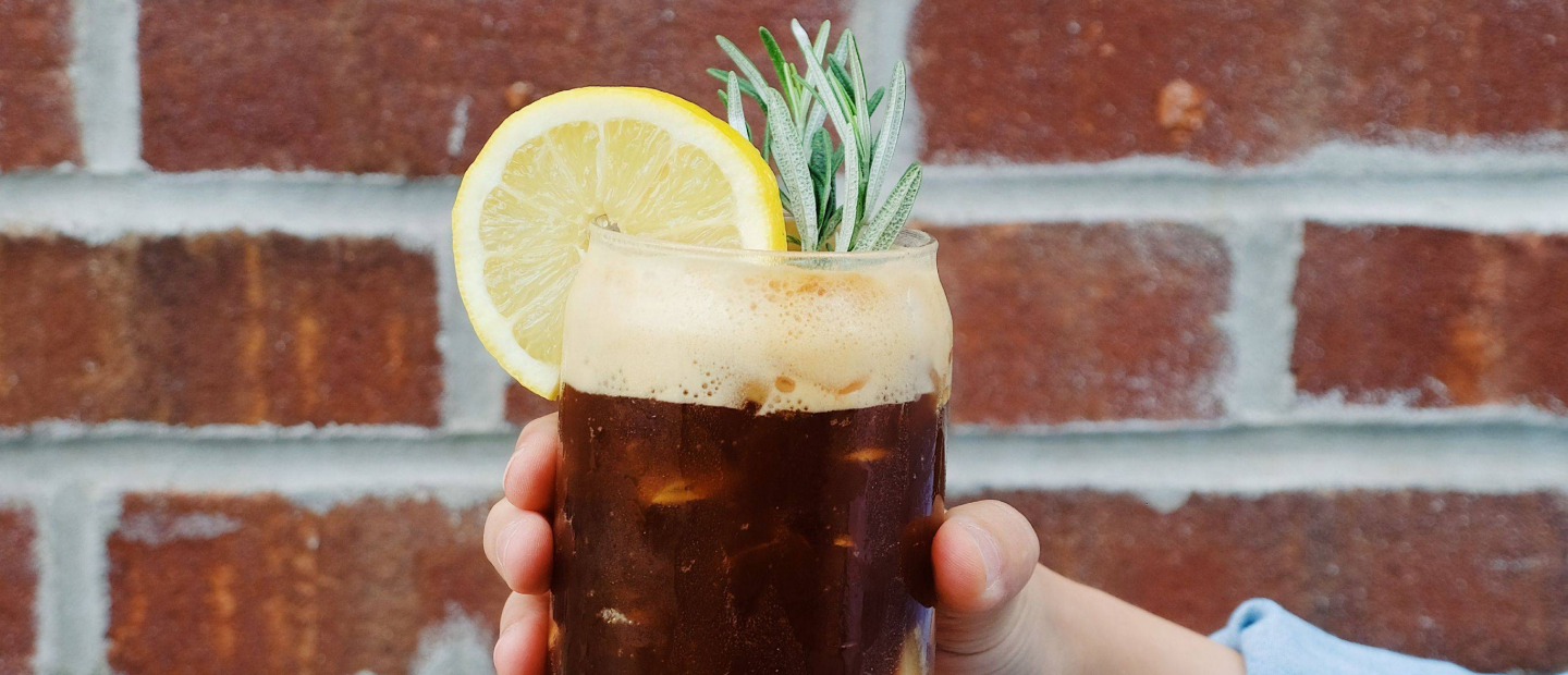 A person holding a glass with the honey bee drink