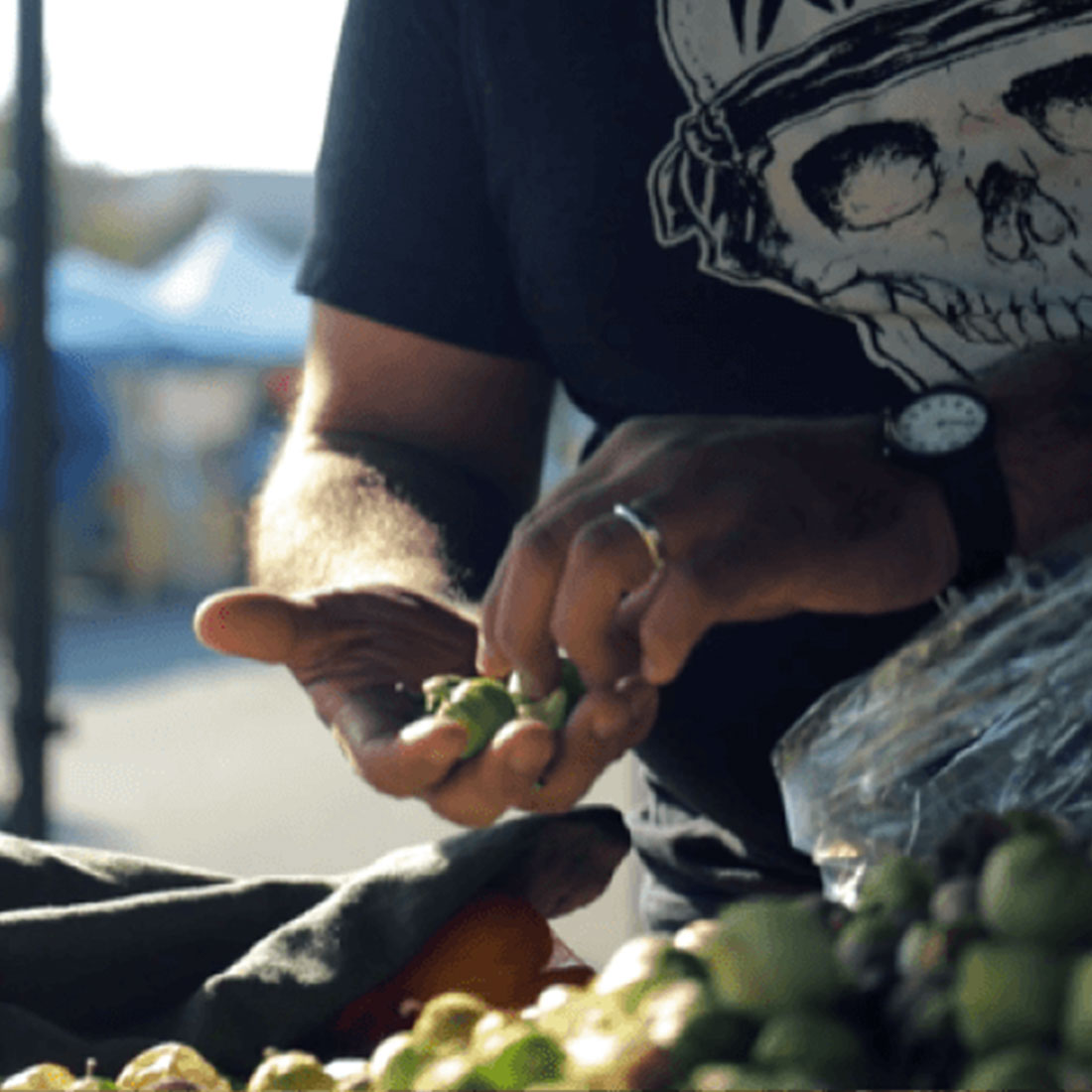 Close up of Ted Montoya picking olives in a Farmer's Market