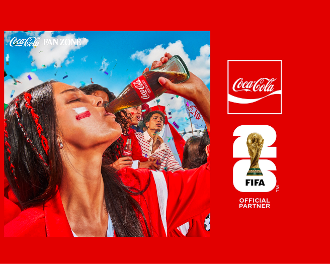 Fans in red celebrating at Coca-Cola FIFA Fan Zone, woman raising a Coke bottle amid confetti and FIFA World Cup branding.